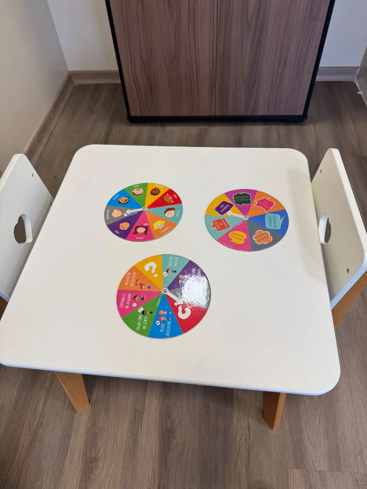 Mesa infantil com discos coloridos usados em atividades sobre emoções